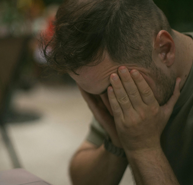 Stressed man with his face in his hands