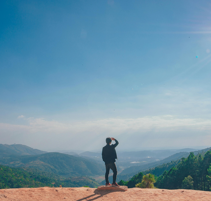Photo of a person on top of a mountain taking in the view